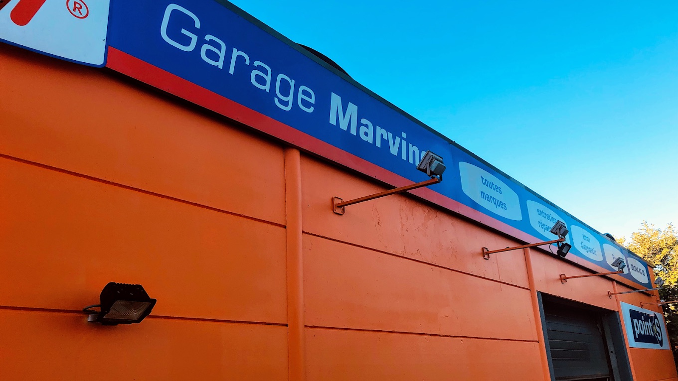 Enseigne du Garage Marvince sur la façade orange