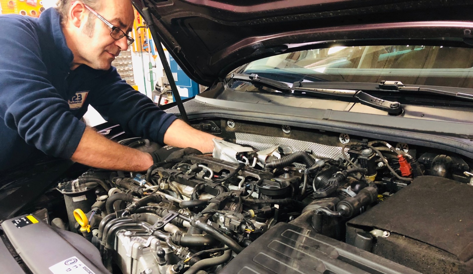 Mécanicien du Garage Marvince intervenant sur un moteur