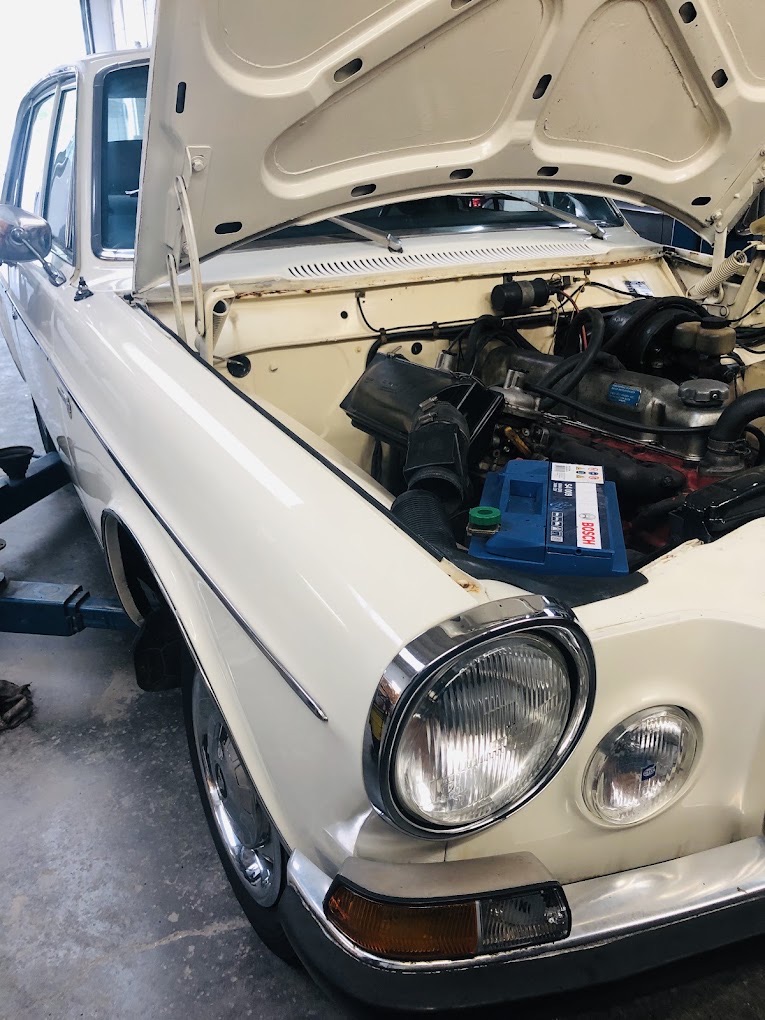 Voiture ancienne capot ouvert, batterie neuve installée